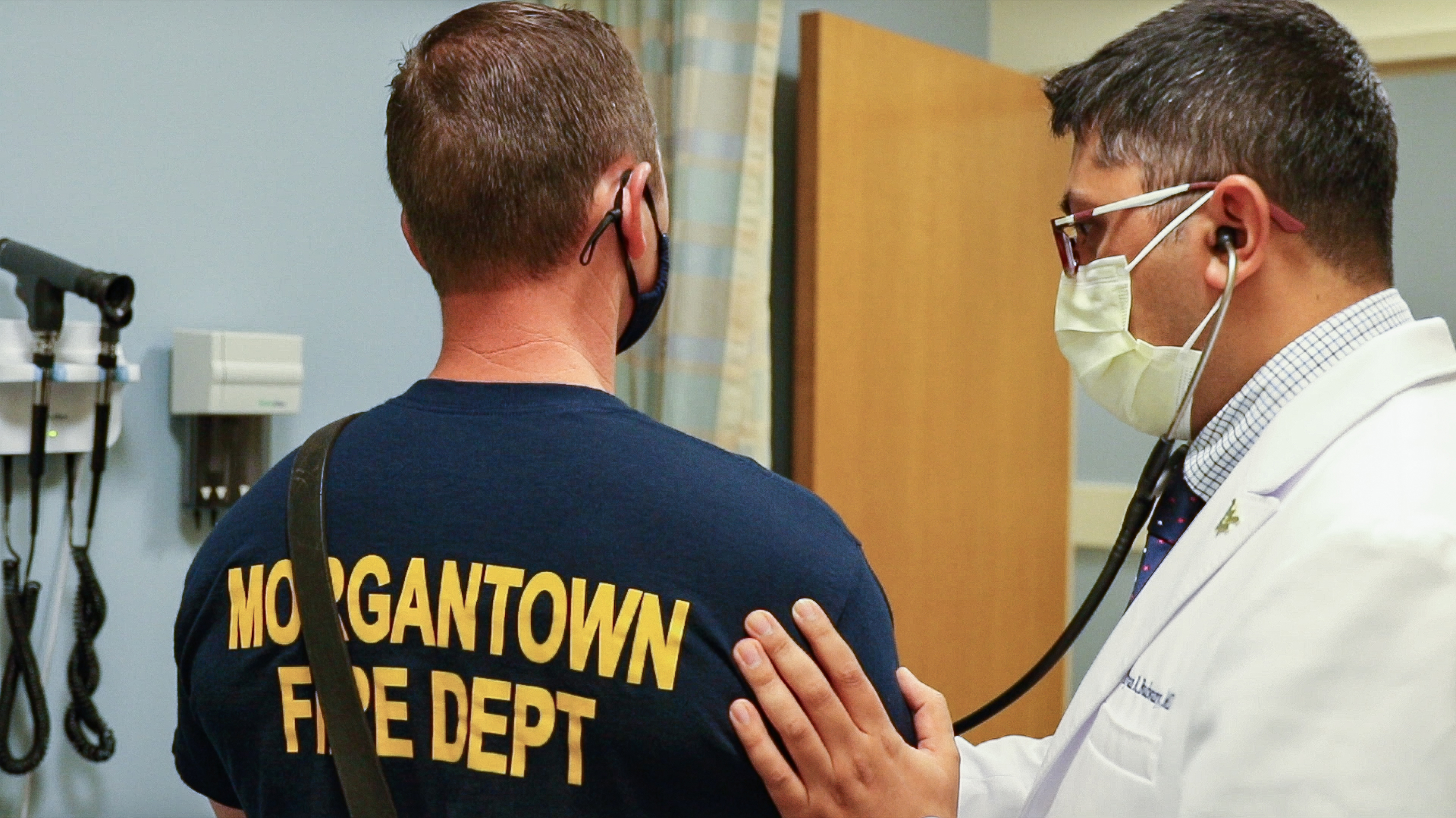 Medical doctor examining Morgantown firefighter using stethoscope. 