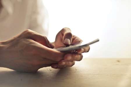 A person’s hands using a smartphone.