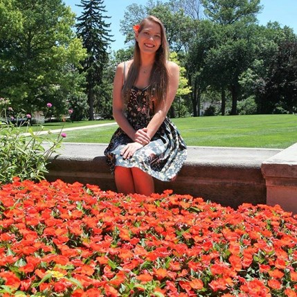 Katie sitting in front of flowers