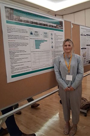 Another research standing in front of her poster.