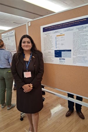 A researcher standing in front of her poster.